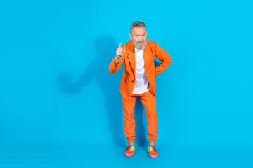 Full length photo of trendy eccentric man point finger you empty space wear orange suit isolated on...