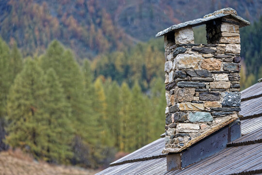Chimney of traditional chalet in frenc akps under rain
