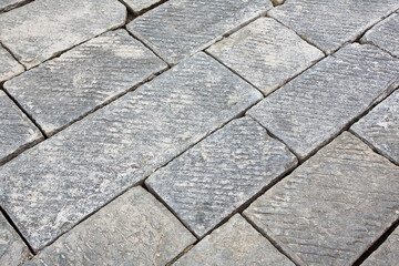 Renovation and restoration of an old traditional stone paving with hard stone blocks on a construction site