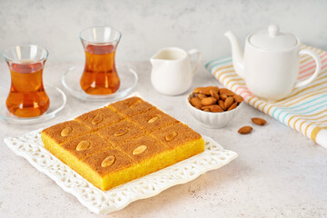 Middle eastern traditional semolina cake basbousa , namoora, hareesa served with tea	