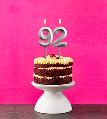 Birthday cake with number 92 candle - Red velvet on a fuchsia background.