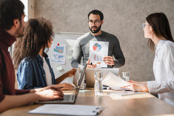 Team of professionals having a meeting in a digital marketing agency. Business people discussing a project in an office. Teamwork and collaboration in a creative workplace.
