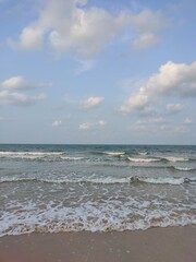 Tranquil Ocean Waves and Cloudy Sky on a Serene Beach Day