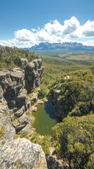 Scenic view of a tranquil pond surrounded by rocky cliffs and lush greenery.