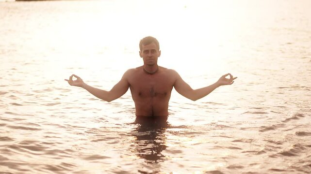 A person meditates in serene waters as the sun sets