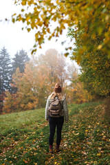 Woman hiking in autumn forest. Outdoor adventure