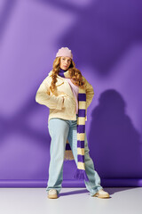 The young woman showcases her unique style with a cozy scarf and playful hat in a colorful setting.