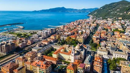 Fototapeten Ligurien Chiavari, a charming coastal town in Italy's Liguria region, viewed from the air showcases its scenic waterfront, vibrant marina, and historic architecture nestled between the green hills  © Viktor