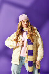 A fashionable young woman enjoys the warmth of her winter attire while showcasing a playful look.