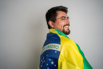 Cheerful man with a Brazilian flag on his back. Smiling cheerful Brazilian man with Brazilian flag...