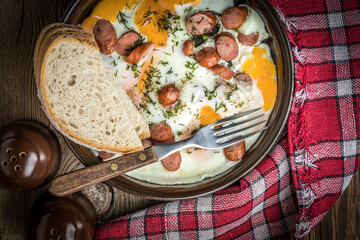 Tasty cooked egg with chopped sausages.