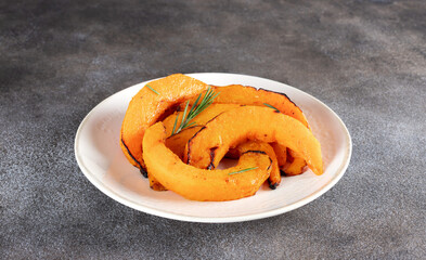 Roasted pumpkin slices with garlic and rosemary. Vegetarian food.