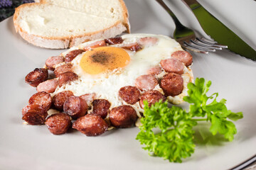 Fried egg with chopped sausage.