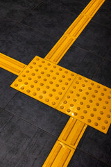 Yellow tactile tiles on the floor provide essential guidance for people with visual impairments,...