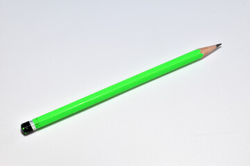 A simple green pencil lies on a white background.