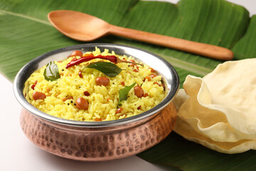  Lemon rice recipe also known as chitrannna or nimmakaya pulihora is a South Indian dish made with rice, tempering spices & curry leaves. Served in a copper bowl with appalam or papad