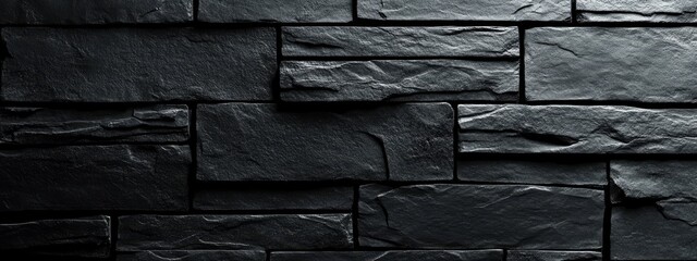 A textured black stone wall featuring rectangular slabs in a modern design.