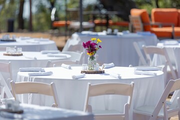 Elegant outdoor event setup with floral centerpiece.