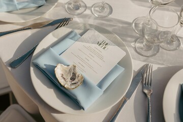 Wedding table set with a menu on a plate in sunlight