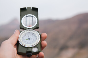 A man holds a compass in nature. © Artvibe