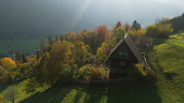 Gozd Martuljek, Slovenia, an alpine hut on the hill with the moutains backdrop, drone footage, aerial video