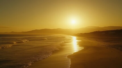 A golden sunset over a calm ocean with waves crashing on the shore.