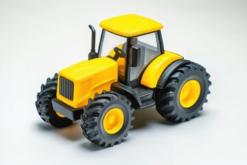 Obraz premium Yellow plastic tractor toy for kids on a white background