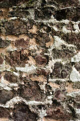 A wall made of stone with a rough texture. The wall is brown and white