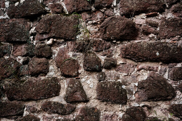 A wall made of stone with a rough texture. The wall is brown and white