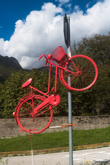 Una bicicletta dipinta di rosso e appesa a un palo per salutare il passaggio del giro d’Italia di ciclismo a Longarone