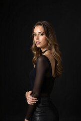 Fototapeta premium Full Body Female Model Isolated on a Black Backdrop Wearing Classy Attire for a Magazine Photoshoot