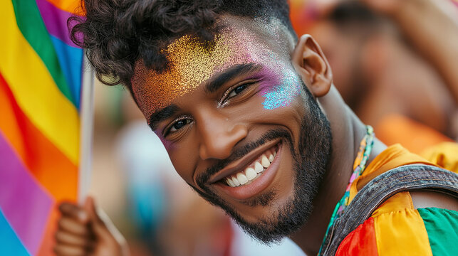A close-up of a fabulous man at the Chicago Pride festival, with vibrant glitter makeup and a bold, colorful outfit. Heâs waving a small rainbow flag with a confident smile, and th
