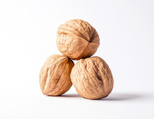 Three Whole Walnuts Stacked on White Background