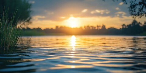 A tranquil lake scene with a golden sunset, calm waters reflecting the sky's hues for a peaceful ambiance.