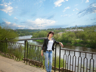 Fototapeta premium Stunning Young Woman Strikes a Pose Against Urban Backdrop.