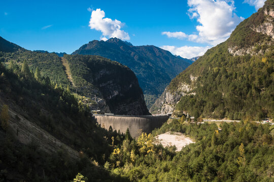 Panorama della diga del Vajont visto dalla strada che porta al borgo di Erto Con le montagne sullo sfondo e qualche nuvola nel cielo