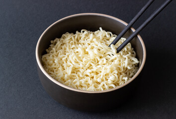 Instant noodles on black background. Vegetarian food. Asian cuisine.