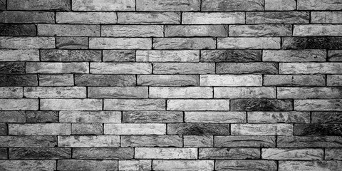 Black and white brick wall texture. A black and white image of a brick wall, displaying the rough texture and layered structure of the bricks.