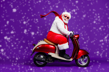 Photo of fat santa claus role man rushing newyear x-mas theme party by bike cool modern style wear sun spectacles trousers hat suspenders isolated purple background