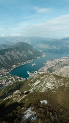 Picturesque drone view of of Kotor bay -Boka Kotorska- South Fjord in Montenegro. Turquoise Adriatic Sea, yachts, cruise liners and old houses with red tiled roofs. Travel concept.