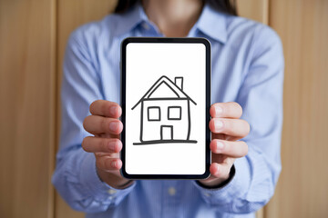 Hand holds device with house sketch, evoking home comfort