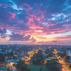 A vibrant sunset over a cityscape, showcasing colorful clouds and lights.