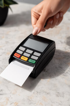 Credit card reader on a simple countertop printing a receipt. Cashless payment terminal for purchases and services