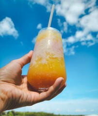 hand holding a glass of orange juice