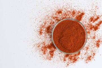 Paprika (ground red pepper) in a petri dish, white background