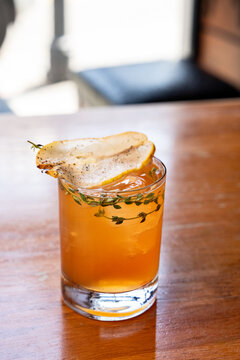 Fall pear cocktail with pear and thyme garnish 