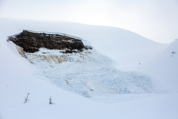 A lone skier navigates the treacherous aftermath of a recent avalanche.