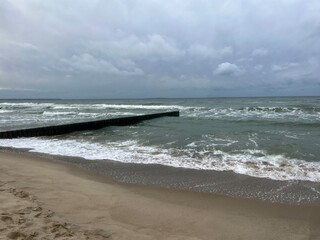 cloudy grey seascape, waved sea horizon, windy at the sea, empty beach