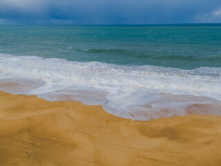Breaking waves at Nazare beach on the Portugal coastal town on the Atlantic ocean shore. Aerial drone view