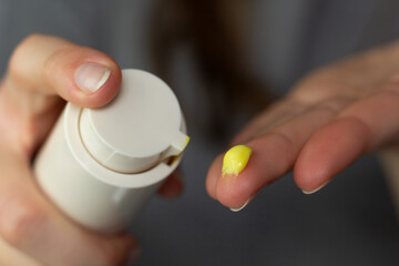 Closeup of a woman using a retinol cream.